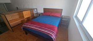 a bedroom with a bed with a red and blue blanket at YAXCHILAN 27 in Cancún