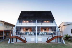 Cette grande maison blanche dispose d'une terrasse couverte. dans l'établissement Pacific Dawn on the Beach, à Wooli