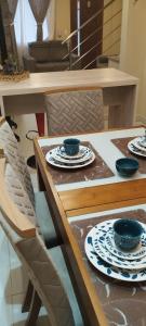 a table and chairs with plates and bowls on it at Casa Joaninha centro in Canela