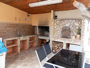 a kitchen with a stone fireplace and a table and chairs at Casa cerca del mar con piscina privada, aire opcional, wifi gratuito, mascotas y playas para perros - ES-184-60 in L'Ametlla de Mar