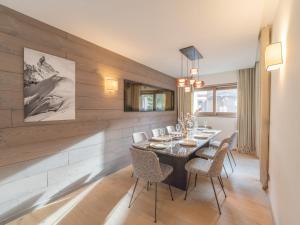 a dining room with a table and chairs at Charmant appartement neuf proche des pistes à Courchevel Le Praz, parking et wifi inclus - FR-1-568-45 in Courchevel