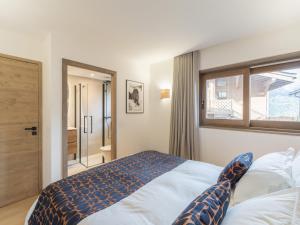 a bedroom with a large bed and a window at Charmant appartement neuf proche des pistes à Courchevel Le Praz, parking et wifi inclus - FR-1-568-45 in Courchevel