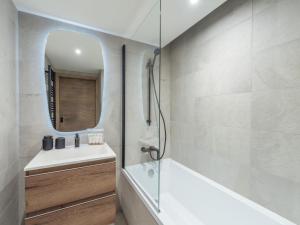 a bathroom with a tub and a sink and a mirror at Charmant appartement neuf proche des pistes à Courchevel Le Praz, parking et wifi inclus - FR-1-568-45 in Courchevel