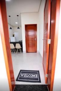 a hallway with a welcome mat in front of a door at Capuzzo Flat 1 in Redenção