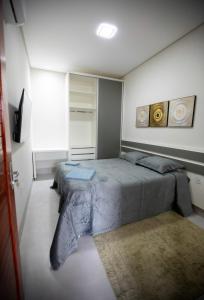 1 dormitorio con cama y alfombra en Capuzzo Flat 1, en Redenção