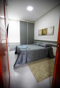 1 dormitorio con 1 cama grande y 1 alfombra en Capuzzo Flat 1, en Redenção