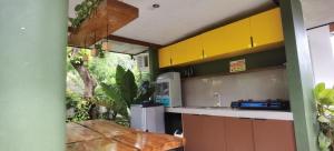 - une cuisine avec des placards jaunes et un évier dans l'établissement Marelocca Beach House, à Calatagan