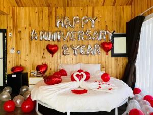 a bedroom with a bed with a happy anniversary sign at Daisy SaPa - Venuestay in Sa Pa