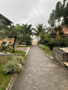 Una calle vacía con palmeras en un patio. en Triplex Praia Brava, en Mangaratiba 17 fotos más