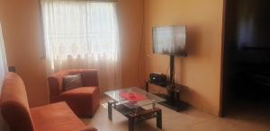 a living room with a couch and a table and a tv at Pacos Place in Puerto Viejo