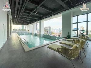 a pool in a building with chairs and a swimming pool at Prince Huan Yu Center Hotel & Residence太子寰宇中心酒店公寓 in Phnom Penh