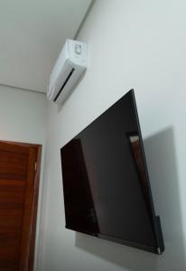a flat screen tv hanging on a wall at Capuzzo Flat 2 in Redenção
