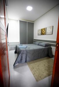 1 dormitorio con cama y alfombra en Capuzzo Flat 2, en Redenção