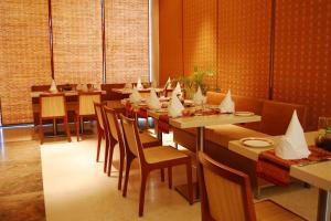 a dining room with a long table and chairs at Cambay Sapphire, Gandhinagar in Gandhinagar