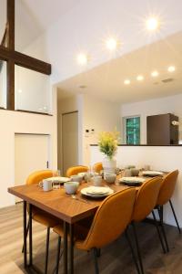 uma sala de jantar com uma mesa de madeira e cadeiras em Albatross Karuizawa em Karuizawa