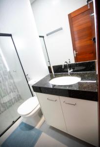 uma casa de banho com um lavatório e um WC em Capuzzo Flat 2 em Redenção