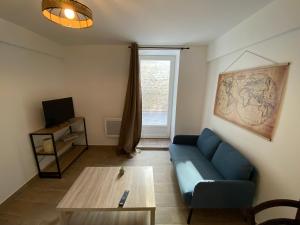 a living room with a blue couch and a table at Giverny Road 