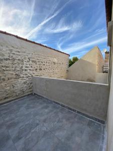 eine Terrasse mit einer Steinmauer und einem Gebäude in der Unterkunft Giverny Road 