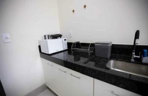 a kitchen with a sink and a counter top at Capuzzo Flat 2 in Redenção