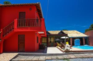 a red house with a swimming pool in front of it at Pousada Bonito Cama e Café in Bonito