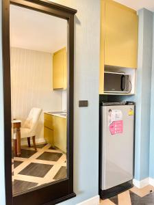 a small kitchen with a refrigerator in a room at Espana Condo Jomtien By AEY in Jomtien Beach