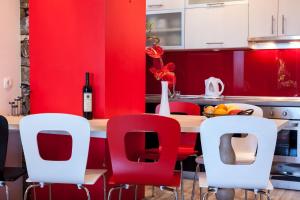 cocina con paredes rojas y mesa con sillas rojas en Holiday Home Porat, en Podgora 24 fotos más