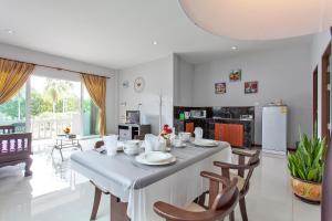 cocina y comedor con mesa y sillas en Maikhao Beach Residence, en Mai Khao Beach