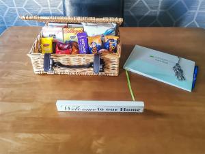 a basket of snacks on a table next to a sign at The Coach House in Drybrook