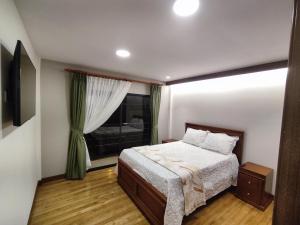 een slaapkamer met een bed en een raam bij GZ GUEST HOUSE in Cuenca