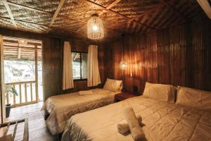 a bedroom with two beds and a teddy bear on the bed at Marika Resort in Badian