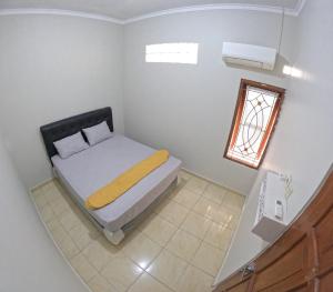 Habitación pequeña con cama y ventana en Nitikan Stay Homestay Jogja, en Timuran