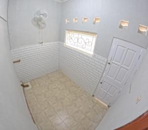 a bathroom with a white door and a window at Nitikan Stay Homestay Jogja in Timuran