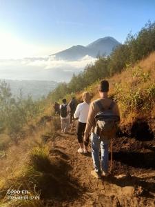 a group of people walking down a dirt trail at Gunung Batur camp in Kintamani