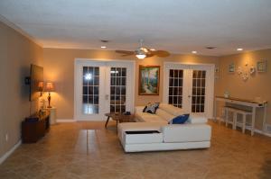 a living room with a white couch and a ceiling fan at Venice villa with heated pool, lanai, near beach in Venice