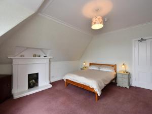 a bedroom with a bed and a fireplace at Albion House in Castle Douglas