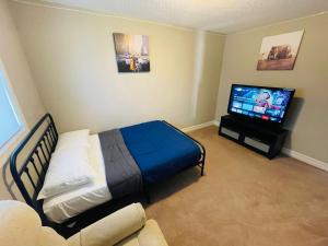 a bedroom with a bed and a flat screen tv at Awesome Bedroom in Edmonton