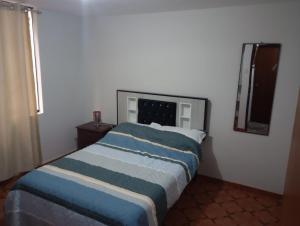 Un dormitorio con una cama azul y blanca y una ventana en Mamita Julia Hospedaje en Lima