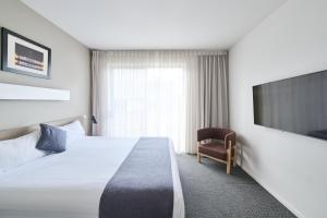 a hotel room with a bed and a tv at Abode Gungahlin in Canberra