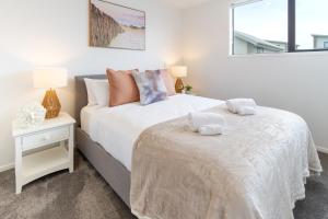 1 dormitorio con 2 camas y mesa con mesita de noche en Sanctuary close to the beach with Sofa Bed, en Christchurch