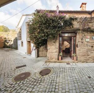 ein Steingebäude mit einer offenen Tür und einem Innenhof in der Unterkunft Casa de Carmen Bañera chimenea de leña y terraza in Corcubión