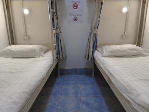 two bunk beds in a room with blue tiles at Ocean Blue Hostel Vientiane in Vientiane