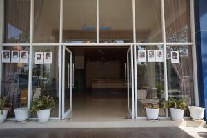 einer offenen Glastür eines Gebäudes mit Topfpflanzen in der Unterkunft OYO 93205 Kusuma Hotel And Convention Hall in Nganjuk