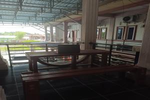 a wooden table with a laptop on top of it at OYO 93207 Merah House in Pekanbaru
