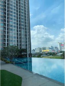 una piscina di fronte a un edificio alto di Supalai Veranda Rama 9 a Ban Na Song