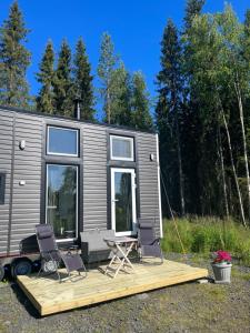 ein winziges Haus mit zwei Stühlen und einer Terrasse in der Unterkunft Luxus Tiny House Saagala in Tornio