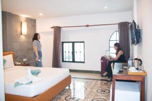Grand Elevation Hotel في بنوم بنه: اثنين من النساء واقفات في غرفة الفندق