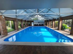 une grande piscine avec un toit en verre dans l'établissement Mounties @ Sussex, à Sussex Inlet
