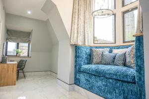 a blue couch in a living room with windows at The Arundell Hotel in Boston +57 photos