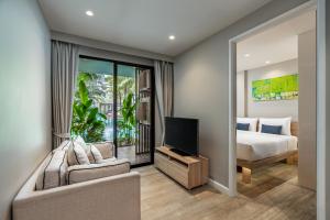 1 dormitorio con 1 cama, TV y sofá en Diamond Resort Phuket - SHA, en Bang Tao Beach