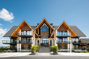 an image of a house with wooden roofs at Góralski Resort Family & SPA in Białka Tatrzańska